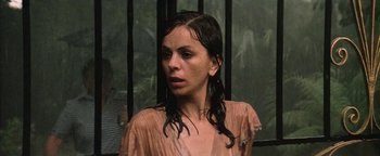 Movie still from “Thirst” (1979), directed by Rod Hardy – A woman with wet hair standing in front of a window; Close Up shot, Over the shoulder angle
