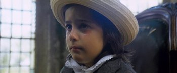 Movie still from “Thirst” (1979), directed by Rod Hardy – A little girl wearing a hat with tears in her eyes; Close Up shot, High angle
