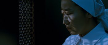 Movie still from “Thirst” (2009), directed by Park Chan-wook – A woman with a white head scarf is looking down; Close Up shot, High angle