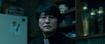 Movie still from “Thirst” (2009), directed by Park Chan-wook – A man wearing glasses and a black shirt; Close Up shot, Low angle