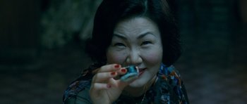 Movie still from “Thirst” (2009), directed by Park Chan-wook – An older woman is holding a cigarette in her mouth; Extreme Close Up shot, High angle