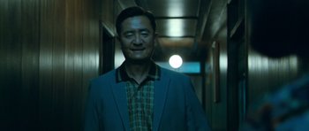 Movie still from “Thirst” (2009), directed by Park Chan-wook – A man wearing a suit and tie in a hallway; Medium shot, Low angle