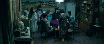 Movie still from “Thirst” (2009), directed by Park Chan-wook – A group of people sitting around a kitchen table; Wide shot, High angle