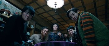 Movie still from “Thirst” (2009), directed by Park Chan-wook – A group of people sitting around a table; Medium shot, High angle