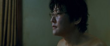 Movie still from “Thirst” (2009), directed by Park Chan-wook – A woman with glasses looking to the side; Close Up shot, Low angle