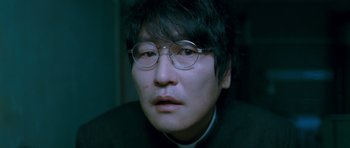 Movie still from “Thirst” (2009), directed by Park Chan-wook – A person wearing glasses; Close Up shot, Low angle