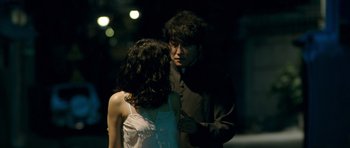 Movie still from “Thirst” (2009), directed by Park Chan-wook – A man and a woman standing next to each other in the dark; Medium shot, Over the shoulder angle