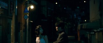 Movie still from “Thirst” (2009), directed by Park Chan-wook – A man and a woman standing next to each other in the dark; Medium shot, Low angle