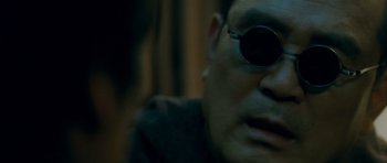 Movie still from “Thirst” (2009), directed by Park Chan-wook – A person wearing a pair of sunglasses; Close Up shot, Over the shoulder angle