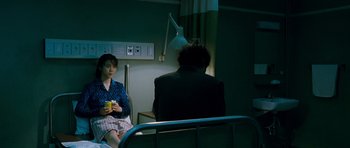 Movie still from “Thirst” (2009), directed by Park Chan-wook – A woman sitting on a hospital bed next to a man; Medium shot, Over the shoulder angle