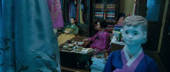 Movie still from “Thirst” (2009), directed by Park Chan-wook – Two women sitting at a table in front of a bunch of books; Wide shot, High angle