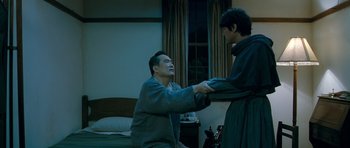 Movie still from “Thirst” (2009), directed by Park Chan-wook – A man and a woman are shaking hands in front of a bed; Medium shot, Over the shoulder angle