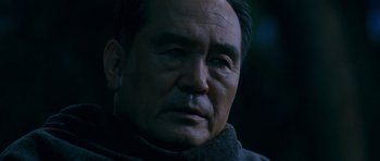 Movie still from “Thirst” (2009), directed by Park Chan-wook – An older man wearing a black jacket looking into the distance; Close Up shot, Low angle