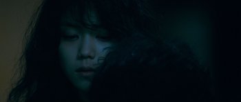Movie still from “Thirst” (2009), directed by Park Chan-wook – A young girl with long black hair is looking at the camera; Close Up shot, Over the shoulder angle