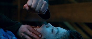 Movie still from “Thirst” (2009), directed by Park Chan-wook – A person is holding a knife over a child's face; Close Up shot, Over the shoulder angle