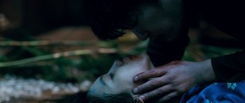 Movie still from “Thirst” (2009), directed by Park Chan-wook – A man and a woman kissing in a forest; Extreme Close Up shot, Low angle