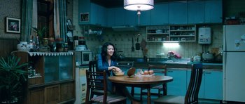 Movie still from “Thirst” (2009), directed by Park Chan-wook – A woman sitting at a table in a kitchen; Wide shot, High angle