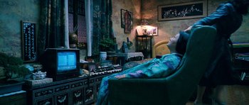 Movie still from “Thirst” (2009), directed by Park Chan-wook – A person sitting in a chair in front of a computer; Wide shot, High angle