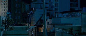 Movie still from “Thirst” (2009), directed by Park Chan-wook – A woman standing on top of a building at night; Wide shot, Overhead angle