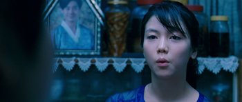 Movie still from “Thirst” (2009), directed by Park Chan-wook – A young woman in front of a picture of a woman; Close Up shot, Over the shoulder angle
