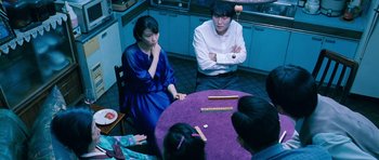 Movie still from “Thirst” (2009), directed by Park Chan-wook – A group of people sitting around a table; Medium shot, High angle