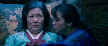 Movie still from “Thirst” (2009), directed by Park Chan-wook – A woman and an older woman sitting next to each other; Close Up shot, Over the shoulder angle