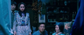 Movie still from “Thirst” (2009), directed by Park Chan-wook – A group of people sitting in a living room next to each other; Medium shot, High angle