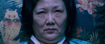 Movie still from “Thirst” (2009), directed by Park Chan-wook – An older asian woman looking at the camera; Close Up shot, Low angle