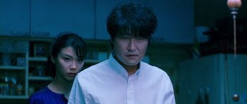 Movie still from “Thirst” (2009), directed by Park Chan-wook – A man and a woman standing next to each other in a room; Close Up shot, Low angle