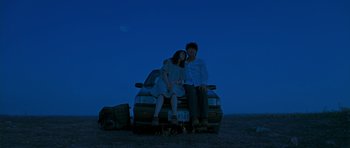 Movie still from “Thirst” (2009), directed by Park Chan-wook – A man and a woman sitting on the back of a car; Wide shot, Low angle