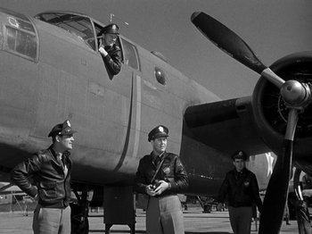 Movie still from “Thirty Seconds Over Tokyo” (1944), directed by Mervyn LeRoy – A group of men standing next to an airplane on the ground; Wide shot, Low angle