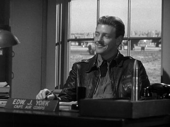 Movie still from “Thirty Seconds Over Tokyo” (1944), directed by Mervyn LeRoy – A man sitting at a table in front of a window; Medium shot, Over the shoulder angle