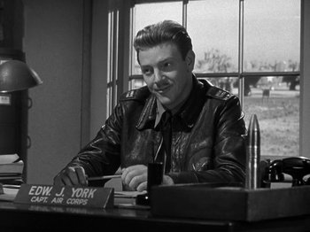 Movie still from “Thirty Seconds Over Tokyo” (1944), directed by Mervyn LeRoy – A man sitting at a table in front of a window; Medium shot, Over the shoulder angle