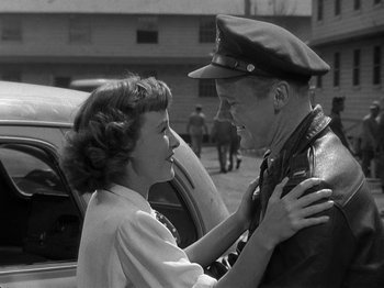 Movie still from “Thirty Seconds Over Tokyo” (1944), directed by Mervyn LeRoy – An old black and white photo of a man and a woman; Medium shot, Over the shoulder angle