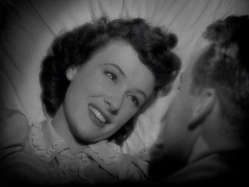 Movie still from “Thirty Seconds Over Tokyo” (1944), directed by Mervyn LeRoy – An old black and white photo of a woman laying in bed; Close Up shot, Overhead angle