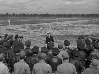 Movie still from “Thirty Seconds Over Tokyo” (1944), directed by Mervyn LeRoy – An old black and white photo of a group of men in uniform; Wide shot, High angle