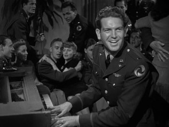 Movie still from “Thirty Seconds Over Tokyo” (1944), directed by Mervyn LeRoy – A man in a military uniform playing the piano; Medium shot, Low angle