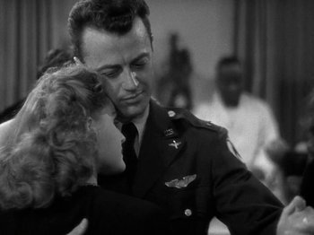 Movie still from “Thirty Seconds Over Tokyo” (1944), directed by Mervyn LeRoy – A man and a woman in military uniforms kissing each other; Medium shot, Over the shoulder angle