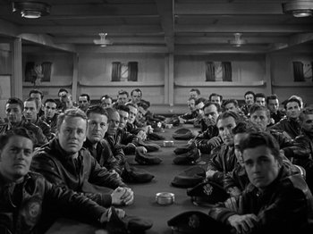Movie still from “Thirty Seconds Over Tokyo” (1944), directed by Mervyn LeRoy – A group of men sitting around a table in a room; Wide shot, High angle