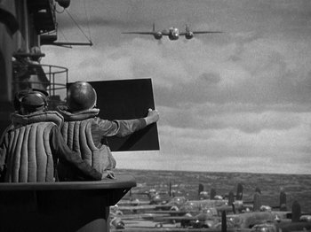 Movie still from “Thirty Seconds Over Tokyo” (1944), directed by Mervyn LeRoy – An old photo of an air plane flying in the sky; Wide shot, Low angle