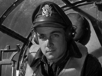 Movie still from “Thirty Seconds Over Tokyo” (1944), directed by Mervyn LeRoy – A man in a pilot's uniform with headphones on; Close Up shot, Low angle