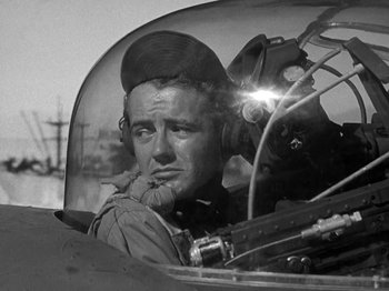Movie still from “Thirty Seconds Over Tokyo” (1944), directed by Mervyn LeRoy – An old photo of a man sitting in an airplane cockpit; Close Up shot, Low angle