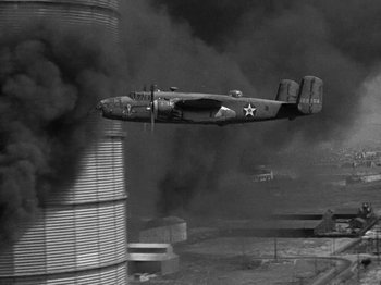 Movie still from “Thirty Seconds Over Tokyo” (1944), directed by Mervyn LeRoy – An airplane is flying over a smoke filled sky; Extreme Wide shot, Low angle