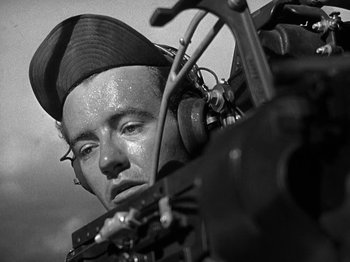 Movie still from “Thirty Seconds Over Tokyo” (1944), directed by Mervyn LeRoy – A man with headphones on looking at a camera; Close Up shot, Low angle