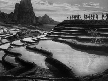 Movie still from “Thirty Seconds Over Tokyo” (1944), directed by Mervyn LeRoy – A black and white photo of a group of people standing on a field; Extreme Wide shot, High angle