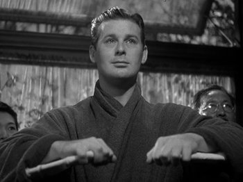 Movie still from “Thirty Seconds Over Tokyo” (1944), directed by Mervyn LeRoy – A black and white photo of a man in a robe; Close Up shot, Low angle