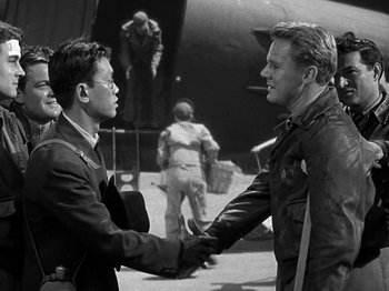 Movie still from “Thirty Seconds Over Tokyo” (1944), directed by Mervyn LeRoy – A black and white photo of two men shaking hands; Medium shot, Over the shoulder angle