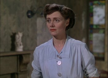Movie still from “This Happy Breed” (1944), directed by David Lean – A woman in a blue dress and a white shirt; Close Up shot, Over the shoulder angle