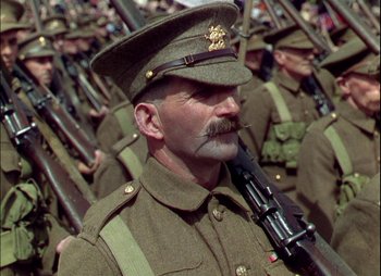 Movie still from “This Happy Breed” (1944), directed by David Lean – A group of men in uniform are marching together; Close Up shot, Low angle