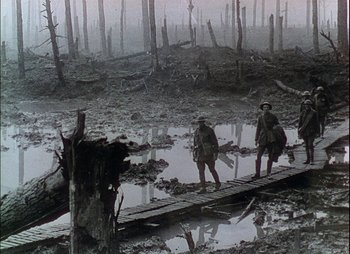 Movie still from “This Happy Breed” (1944), directed by David Lean – Two men are standing on a bridge in the mud; Extreme Wide shot, High angle